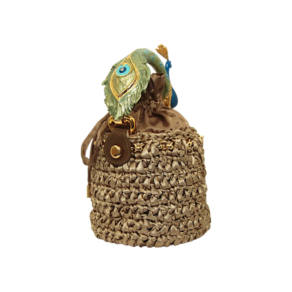 Handcrafted bronze crochet bucket bag showing the sculpted green peacock tail handle with enamel and gold details