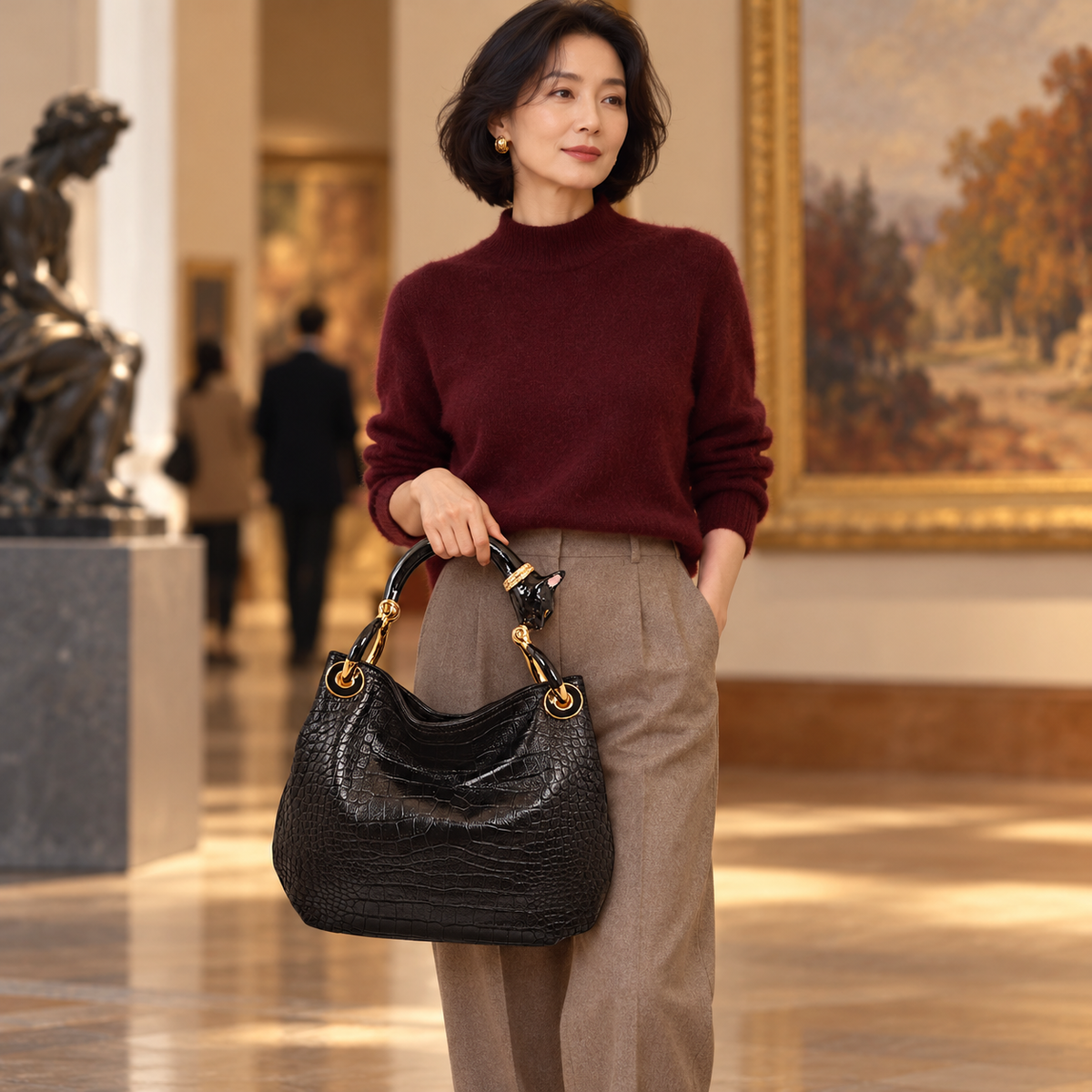 Woman carrying the INGA black croco-embossed leather medium handbag with black cat sculpture handle, styled for autumn.